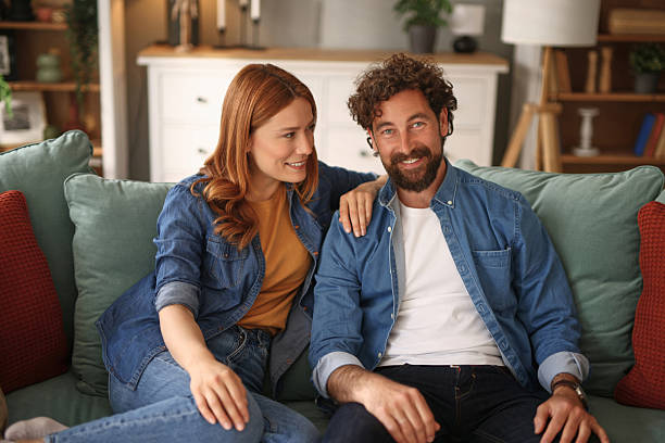 istock Happy couple relaxing and talking on sofa at home 2222398513