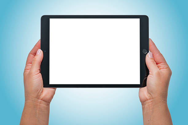 Hands holding digital tablet on blue gradient background. Mock-up of a blank screen for the application. Device screen or touch screen