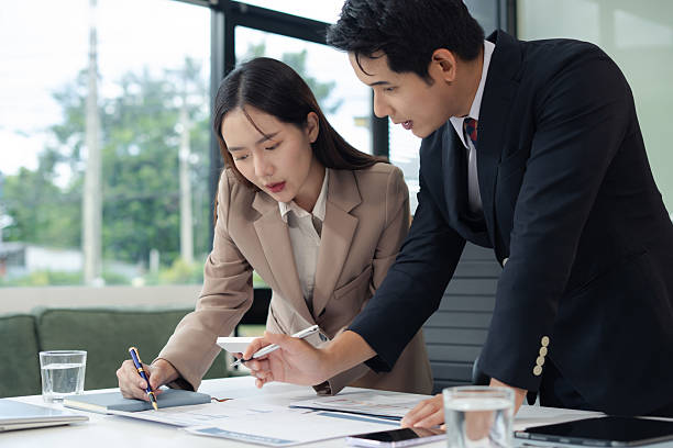 istock Business team analyzing documents, graphs, and data with a laptop, tablet, and smartphone. Collaboration, strategy, and success in a modern office. 2222402190