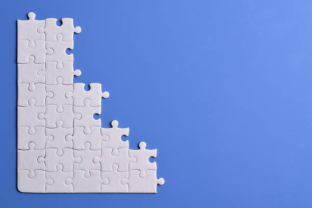 istock White puzzle pieces on blue background 2222403369