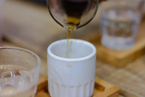 istock Close up view of hot coffee being poured into a small white cup 2222403449