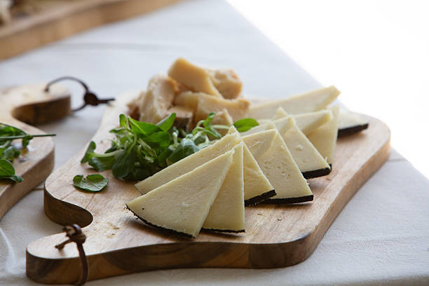 istock Manchego cheese slices with garnish on wooden serving board 2222403544