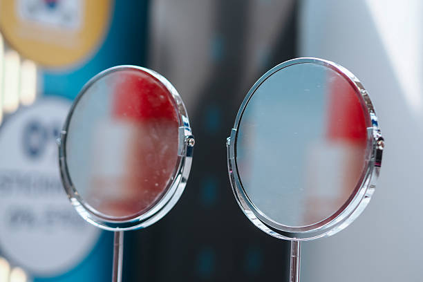 A sleek modern round tabletop mirror with a shiny chrome frame