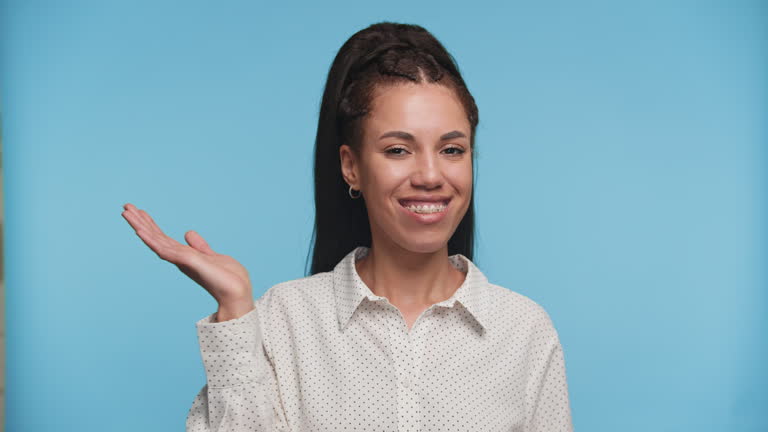 Woman weighing options with unsure expression on blue