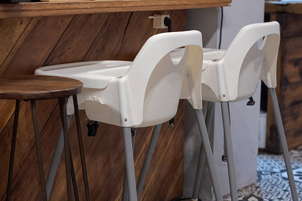 istock Two empty white baby high chairs ready for use in a modern cafe interior 2222403886