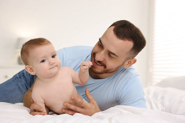 istock Father with his cute baby on bed at home 2222404208