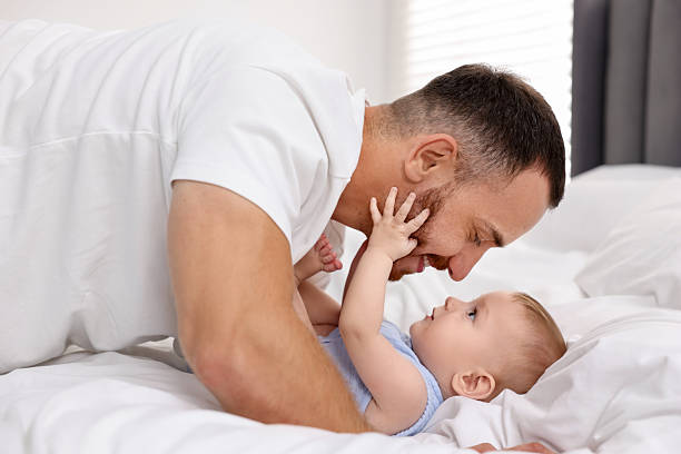 istock Father with his cute baby on bed at home 2222404257