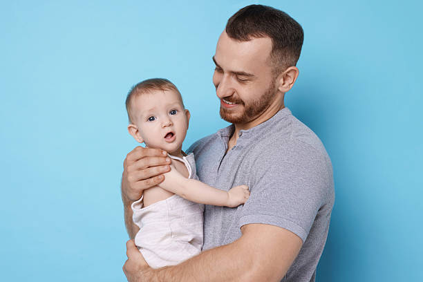 istock Father with his cute baby on light blue background 2222404306
