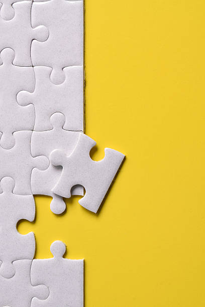 istock White puzzle pieces on yellow background 2222404693