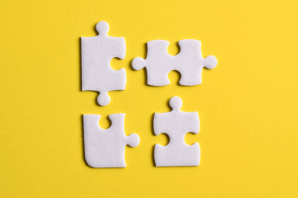 istock Four puzzle pieces on yellow background 2222405570