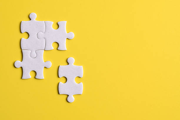 istock Four puzzle pieces on yellow background 2222405578