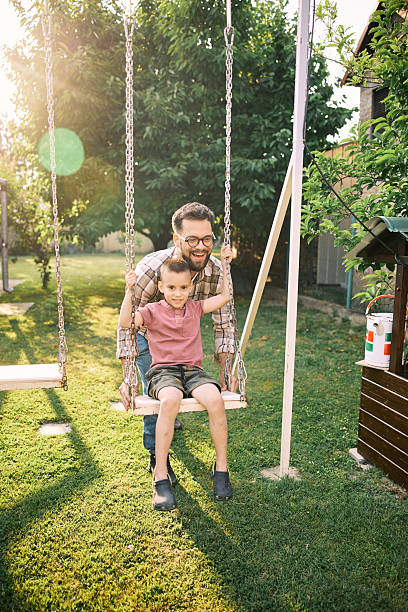 istock Father and son having fun in backyard on a swing. 2222406061
