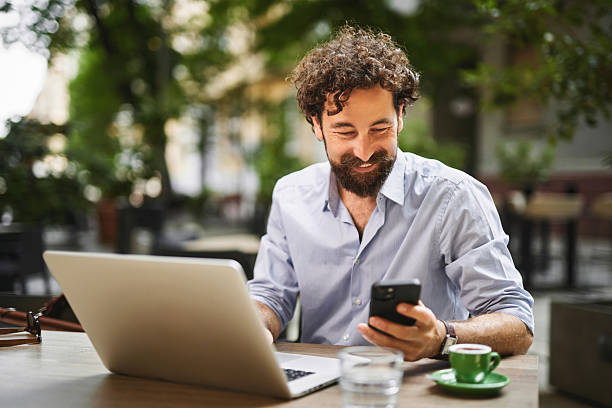 istock Freelancer working on laptop and smartphone at outdoor cafe 2222406511