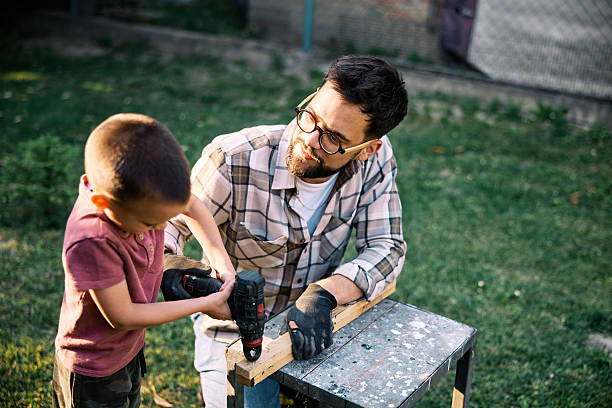 istock Craftsman with his son drilling and wood processing in backyard. 2222406688