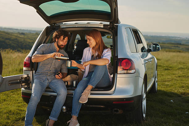 istock Couple enjoying a relaxing picnic by their car 2222408540