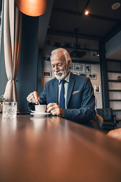 istock Elderly Man Enjoying Coffee in a Stylish Contemporary Cafe Setting 2222414519