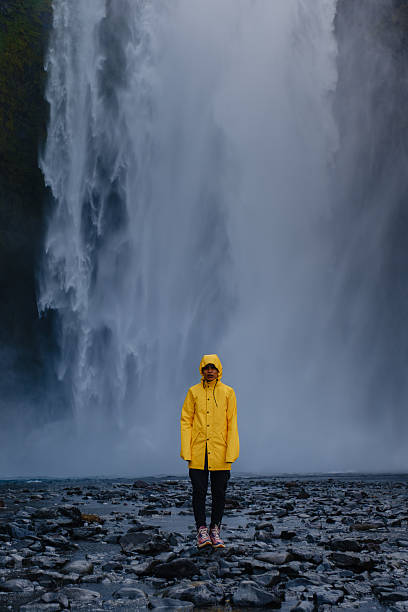 istock Discovering Skogafoss waterfall in Iceland while wearing a bright yellow rain jacket 2222414819