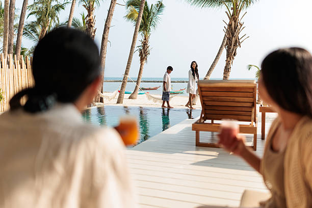 istock Children enjoy by the pool, while parents relax with refreshing drinks 2222418234