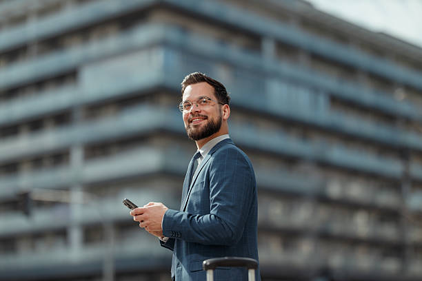 istock Smiling Businessman Using Smartphone Outdoors 2222418668