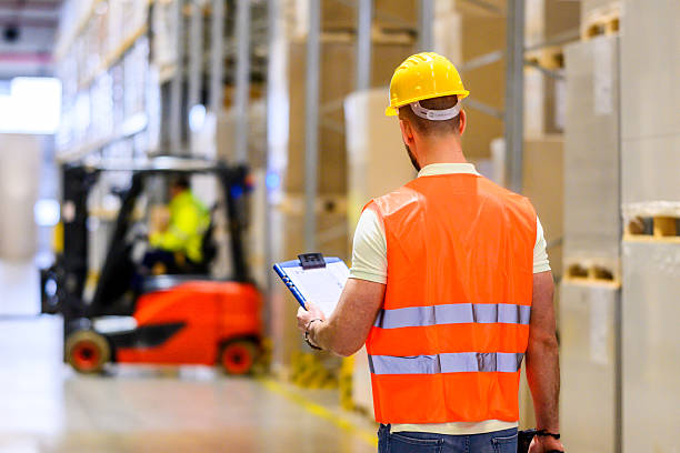 istock Industrial Storage Worker with Checklist and Forklift in Background 2222421709