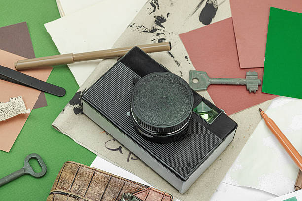istock Flat lay with vintage camera, cassette, notebook, key and research tools on green background 2222421935
