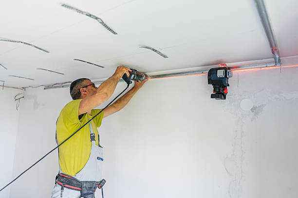 istock Mature Worker Installing Gypsum Board Profiles With A Drill On The Ceiling In An Empty Apartment Under Renovation 2222423643
