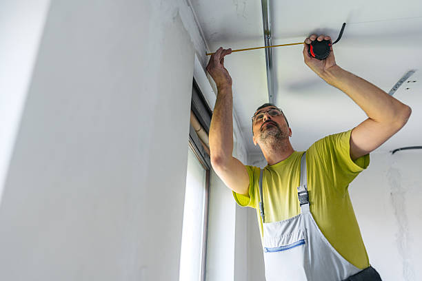 istock Mature Worker Measuring With A Meter While Installing Gypsum Board Profiles On The Ceiling In An Empty Apartment Under Renovation 2222423765