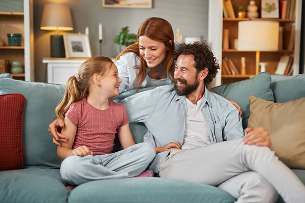 istock Happy family relaxing together on sofa at home, sharing precious moments 2222425405