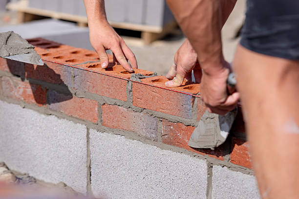 istock Close-up of Bricklayer laying red bricks on building site 2222427777