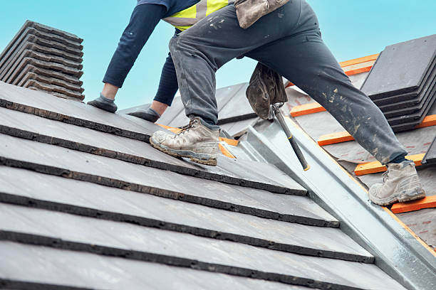 istock Construction worker carefully places roof tiles on a sloped surface while standing on top of a building  showcasing the effort involved in roofing work 2222427987
