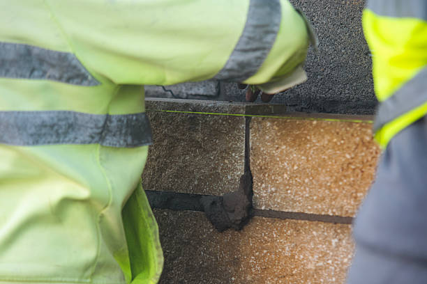 istock Close-up of skilled bricklayer working on construction site laying bricks for wall construction 2222428000
