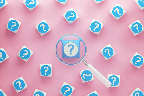 istock White Magnifying Glass Over Question Marks Written White And Blue Cubes On Pink Background 2222429443
