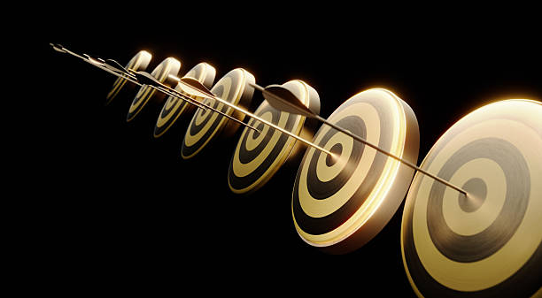 istock Gold Colored Arrows Hitting Bull's Eye Targets On Black Background 2222430539