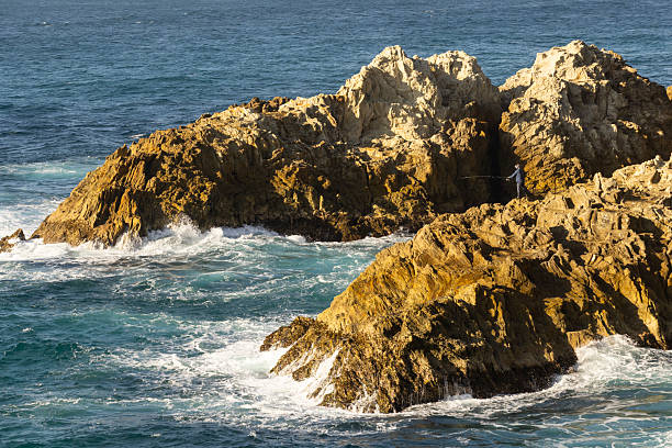 solo fisherman on rocks at North Gorge, Point Lookout, North Stradbroke Island, Queensland.