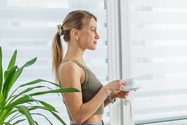 istock Side profile of woman drinking coffee indoors. Morning routine 2222434446