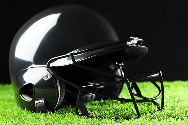 istock Baseball helmet on artificial grass against black background, closeup 2222435175