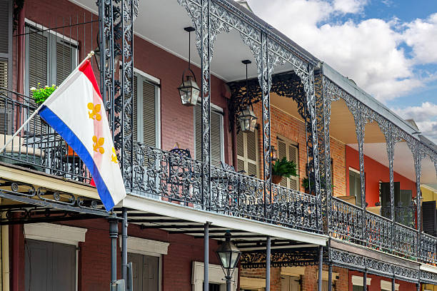 istock NOLA flag with gold Fleur-de-Lis and architecture with balconies and columns adorned with ironwork in the French Quarter, New Orleans, Louisiana 2222440278