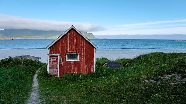 istock Charming red cabin by the tranquil beach in Norway with stunning coastal views 2222440735