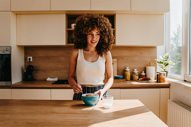 istock Young woman preparing breakfast in a modern kitchen 2222444549