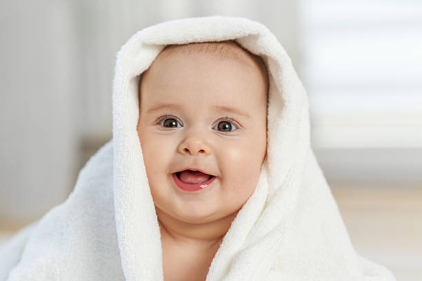 istock Laughing baby wrapped in white towel. Close up 2222446615