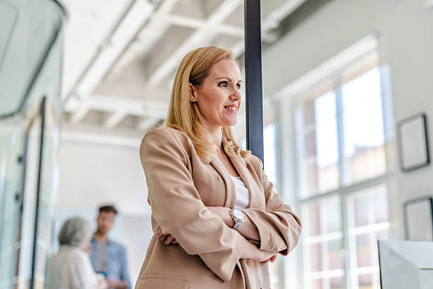 istock Professional woman stands confidently in modern office during collaborative work session 2222450180
