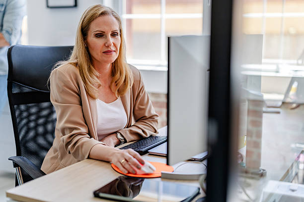 istock Professional adult working diligently at a modern office desk with computer and accessories 2222450620