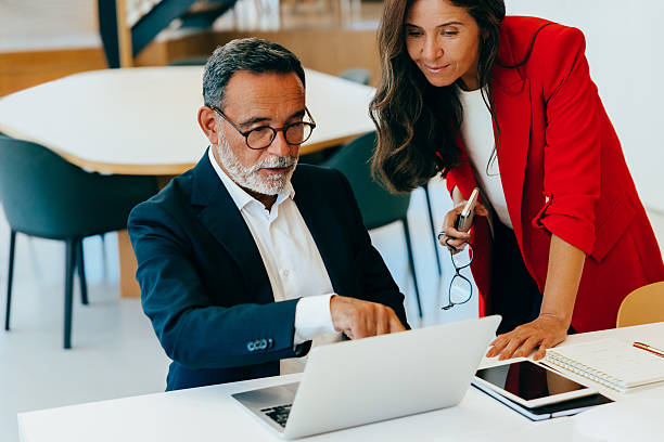 istock Senior professionals discussing documents while working on a laptop at the office 2222452233