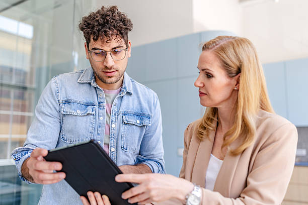 istock Two business professionals discussing work-related tasks in a modern office setting during the afternoon hours 2222453158