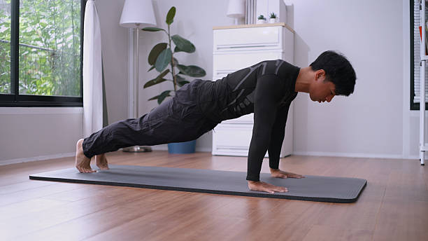 istock Eco-Friendly Morning Routine – Push-Ups in Sunlit Living Room. 2222453687