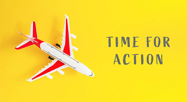 istock Small airplane is on a yellow background with the words Time for Action 2222453890