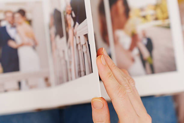 istock flipping through a photo book with wedding photos 2222455397