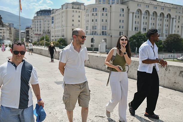 Joyful Friends Exploring Old Bridge Together While Enjoying Warm Sunshine And Scenic Sightseeing