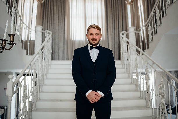 istock a Beautiful and happy groom on a large beautiful staircase. 2222457604