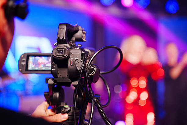 istock A professional videographer is filming a concert on stage. blurred stage. 2222458017